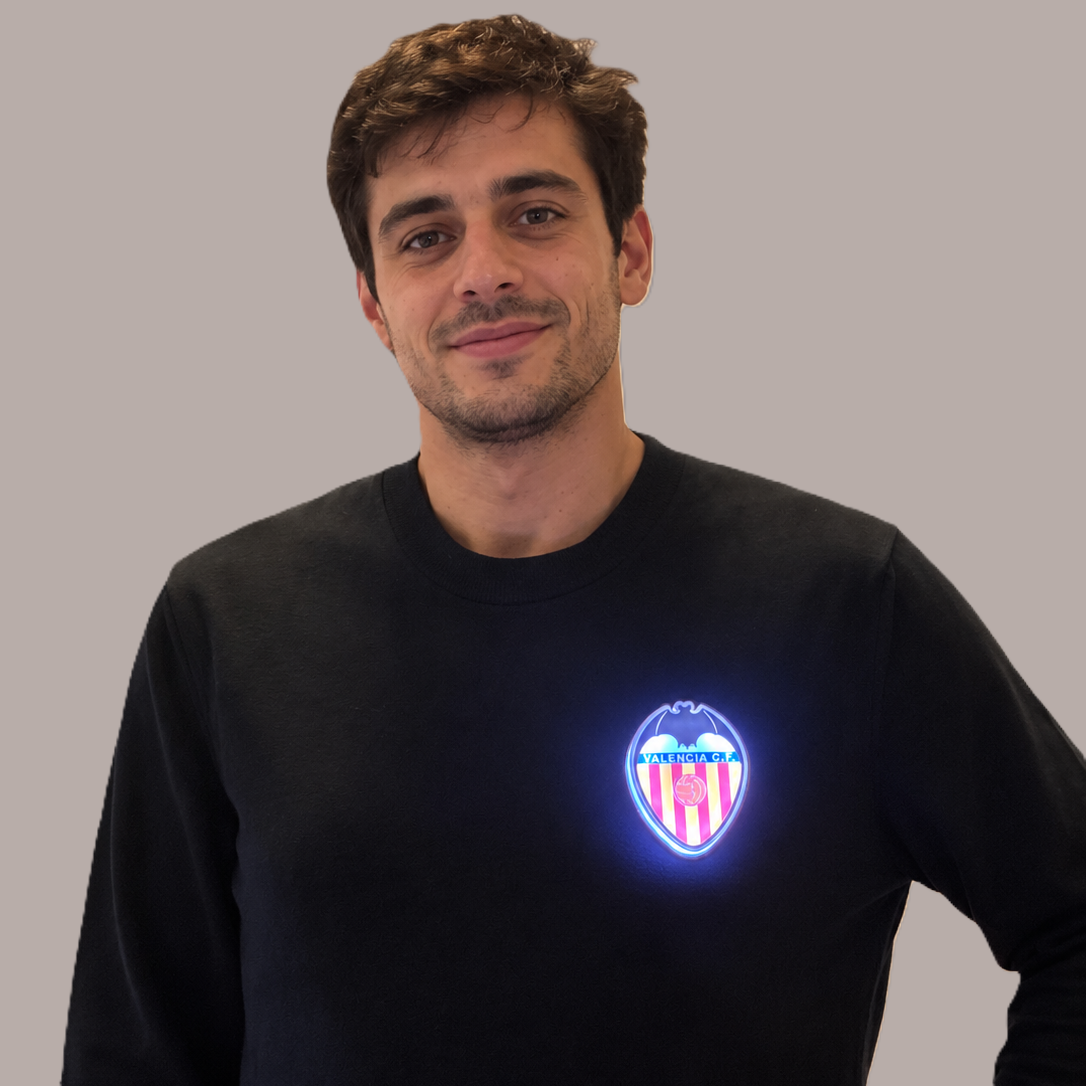 Persona llevando el escudo oficial iluminado Pin LED del Valencia CF en una mochila, chaqueta o camiseta