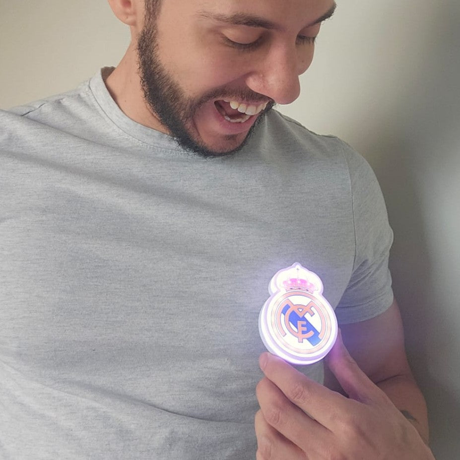 Persona llevando el escudo oficial iluminado Pin LED del Real Madrid  en una mochila, chaqueta o camiseta
